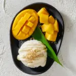 Delicious Mango Sticky Rice topped with fresh mango slices and coconut cream