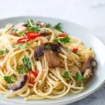 Miso pasta with shiitake mushrooms garnished with green onions in a bowl