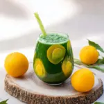 Plum Mango Kale Smoothie in a glass with fresh ingredients around